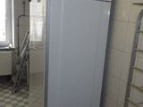un réfrigérateur blanc dans une cuisine au sol à carreaux