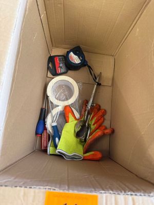 une boîte en carton avec un tas d'outils à l'intérieur