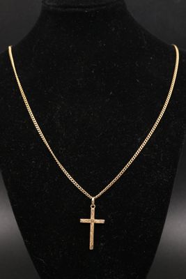 un collier avec une croix en or sur un mannequin, un mannequin, un mannequin, un mannequin, un mannequin, un mannequin, un mannequin, un mannequin, un manne
