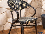 a black and white chair sitting on a wooden floor next to a potted plant