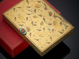 a gold and red box with a floral design on it