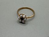 a gold ring with pearls on it on a table