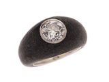 une image représentant une bague ornée d'un diamant posé sur une pierre noire