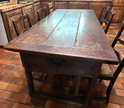 une table et des chaises en bois dans une pièce au sol carrelé