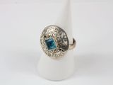 a close up of a ring with a blue stone in it
