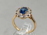 un gros plan d'une bague en or sertie d'un saphir bleu et de diamants blancs