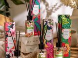 an assortment of reeds and candles on a table with flowers