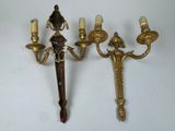 two antique brass wall sconces with candles and a mirror