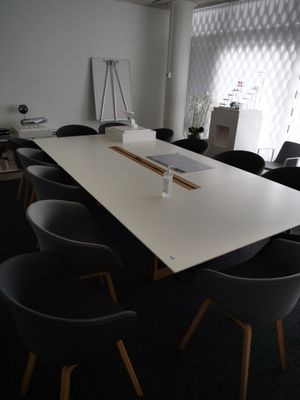 une longue table entourée de nombreuses chaises dans une pièce