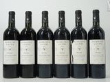 six bouteilles de vin sont alignées sur une table
