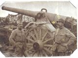 two men in uniform standing next to a large cannon