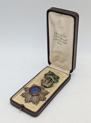 an image of a small box with a broochet and a medal in it