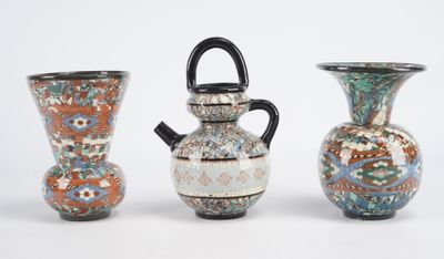 trois vases posés l'un à côté de l'autre sur une surface blanche