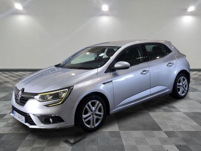 La voiture argentée est garée dans une grande pièce au sol à carreaux.