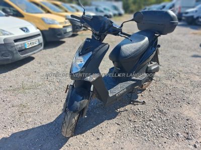 un gros plan d'un scooter garé sur un parking