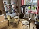 four chairs in a room with bookshelves in the background