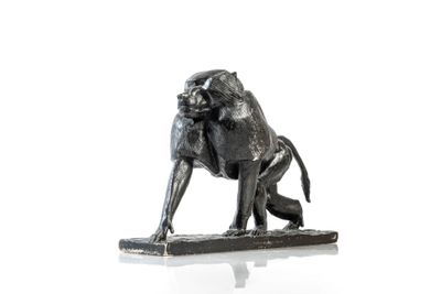 statue représentant un babouin assis sur un morceau de bois posé sur une surface blanche