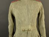 a green jacket on a mannequin stand against a black background