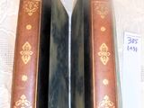two old books sitting on a table with a price tag