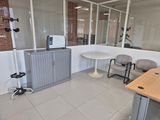 a room with a table, chairs, and a microwave in it