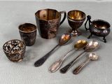 a lot of silver spoons and cups on the table