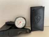 a black wallet and a white thermometer next to a black wallet
