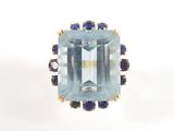 une image représentant une bague sertie d'une topaze bleue entourée de saphirs bleus