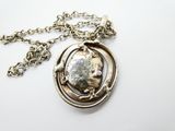 un gros plan d'un collier avec une pièce suspendue à une chaîne