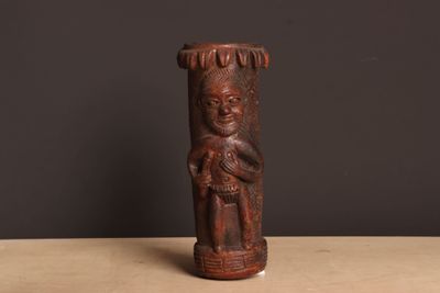 un gros plan d'une statue en bois posée sur une table, sur fond noir