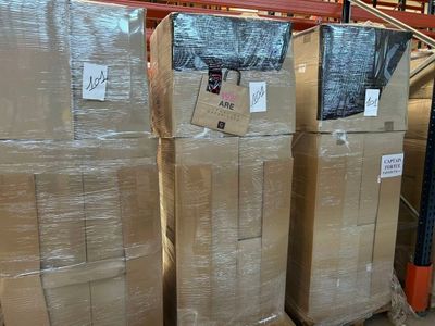 Les cartons sont empilés sur des palettes dans un entrepôt et portent une étiquette