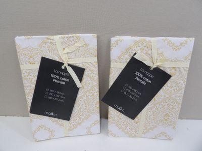 une paire de sacs-cadeaux blancs et dorés, ornés d'étiquettes noires