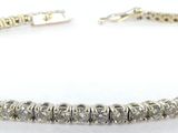 a close up of a silver bracelet on a white background