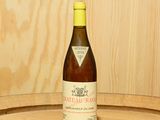 une bouteille de vin posée sur un tonneau en bois