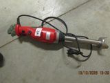 a red drill on the floor next to a black and white dog