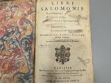 an old book is open on a table with a tag on it
