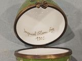 a green and white bowl with a gold rim