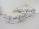 two white dishes with blue designs on them on a table