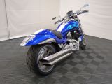 a picture of a blue motorcycle parked on a black and white checkered floor