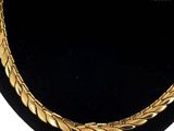 a close up of a gold necklace on a mannequin display