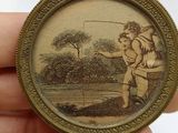 someone is holding a miniature picture of a man fishing in a lake