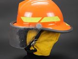 an orange hard hat with a safety face shield on top of it