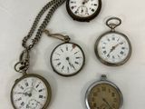 five different types of pocket watches on a white surface