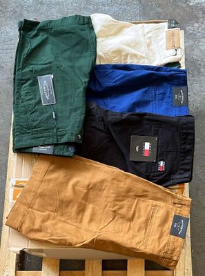 plusieurs paires de pantalons pour homme posées sur une caisse en bois