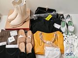 de nombreuses paires de chaussures, des sacs et d'autres objets posés sur la table
