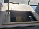 a sink with a faucet and a basket on the counter