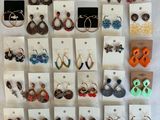 un gros plan sur un lot de boucles d'oreilles exposées sur un mur