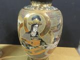 a gold vase with a picture of a woman on it