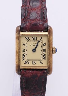 une image d'une montre en or avec des chiffres romains sur le cadran