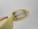 a person holding a yellow electric toothbrush in their hand