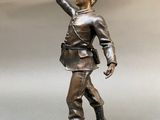 bronze statue of a boy with his hand up in the air